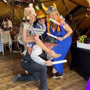 Guests posing in front of Magic Mirror with props in Tape Wedding