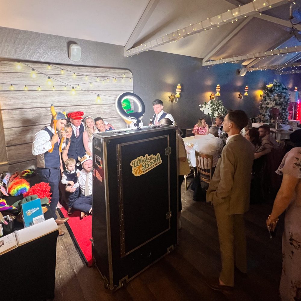 guest in the photo booth with a wooden festoon backdrop using a magic mirror at a wedding in nottinghamshire cockliffe country hotel